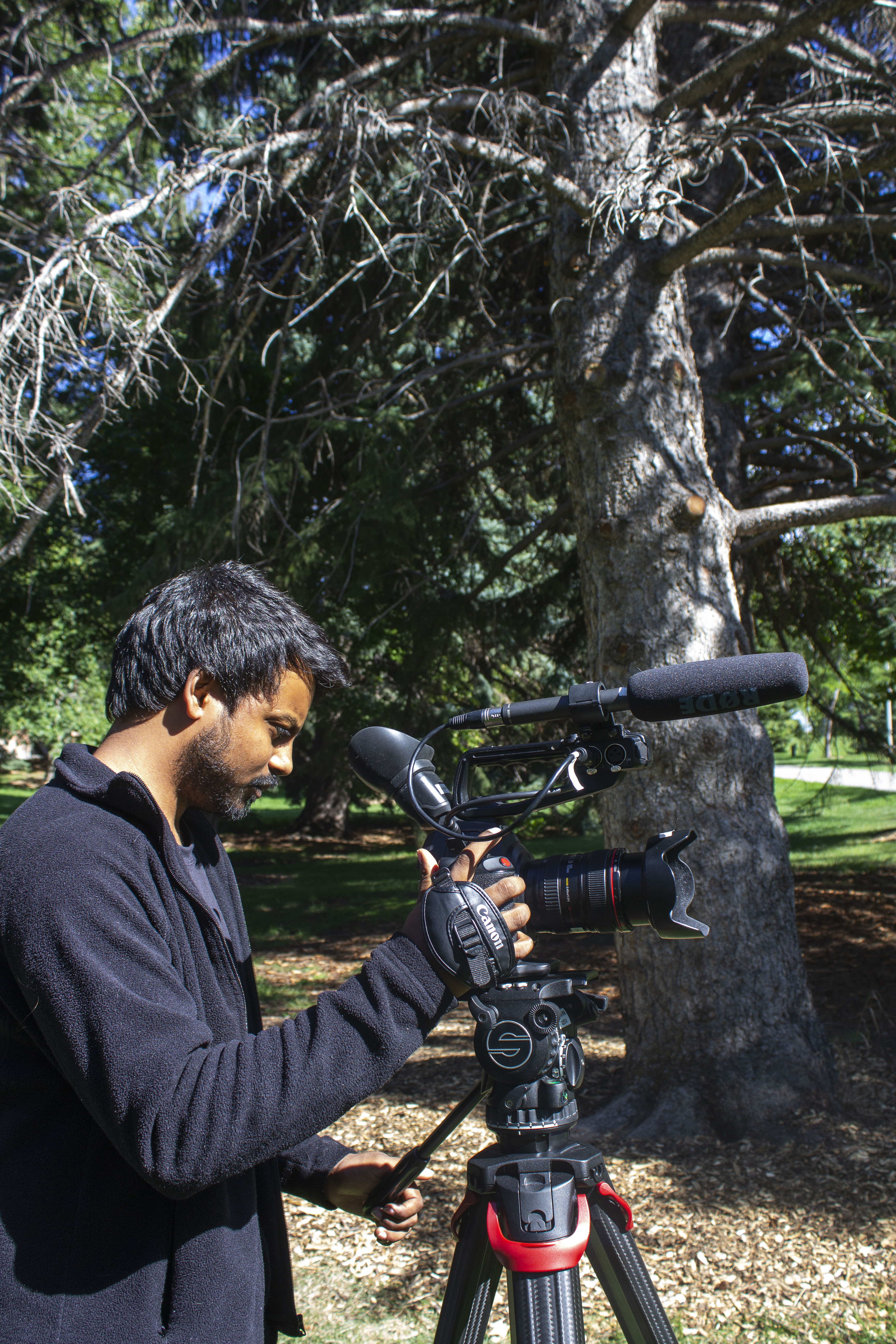 Anirudh Nedanooru on location with a Canon cinema camera and shotgun microphone